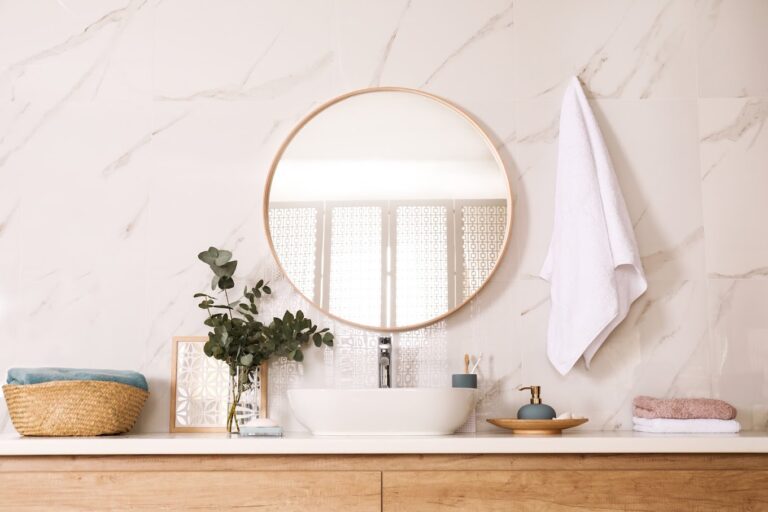 Stylish bathroom interior with vessel sink and round mirror