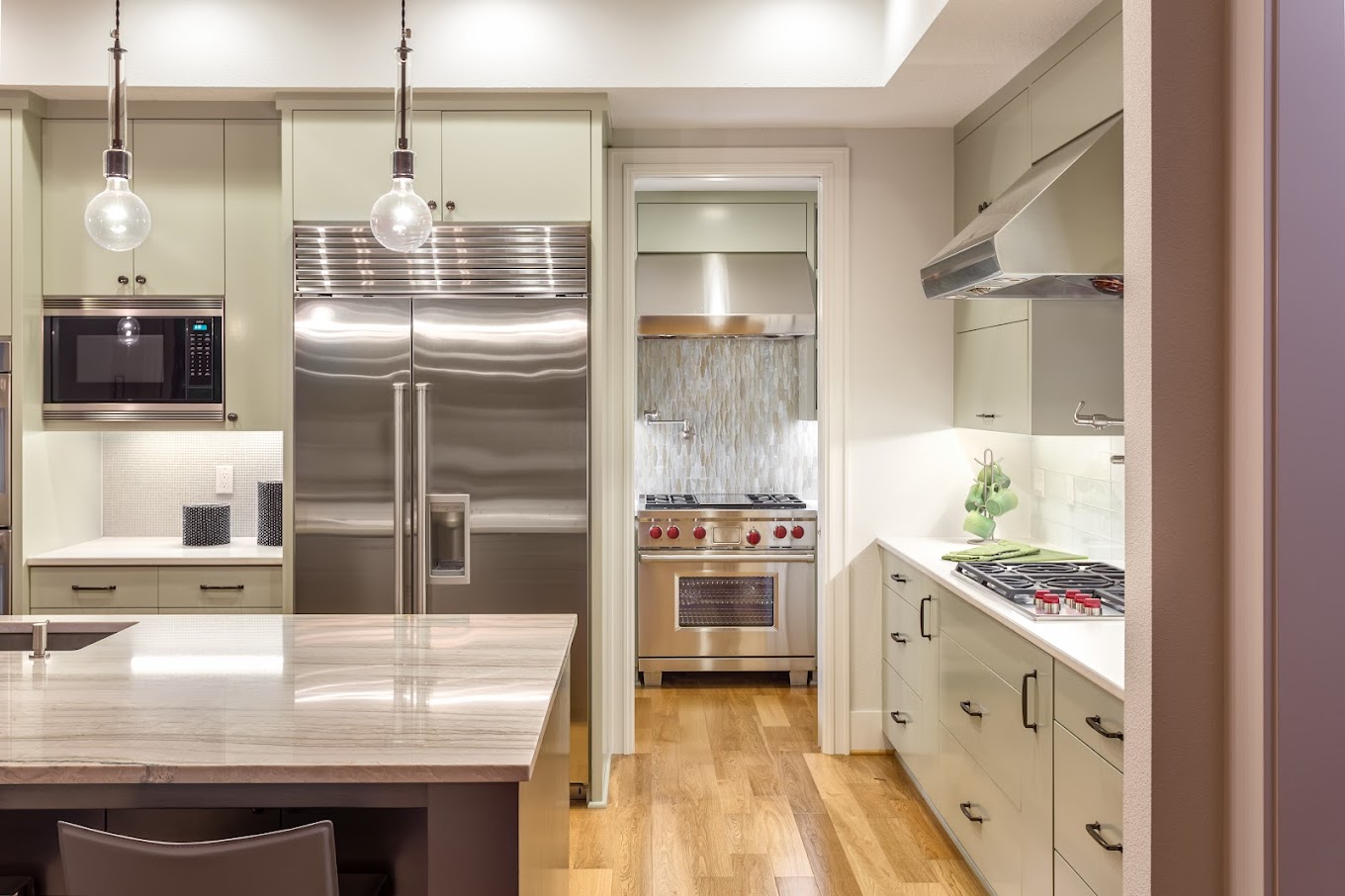 Kitchen with Island, Sink, Cabinets, and Hardwood Floors in New Luxury Home