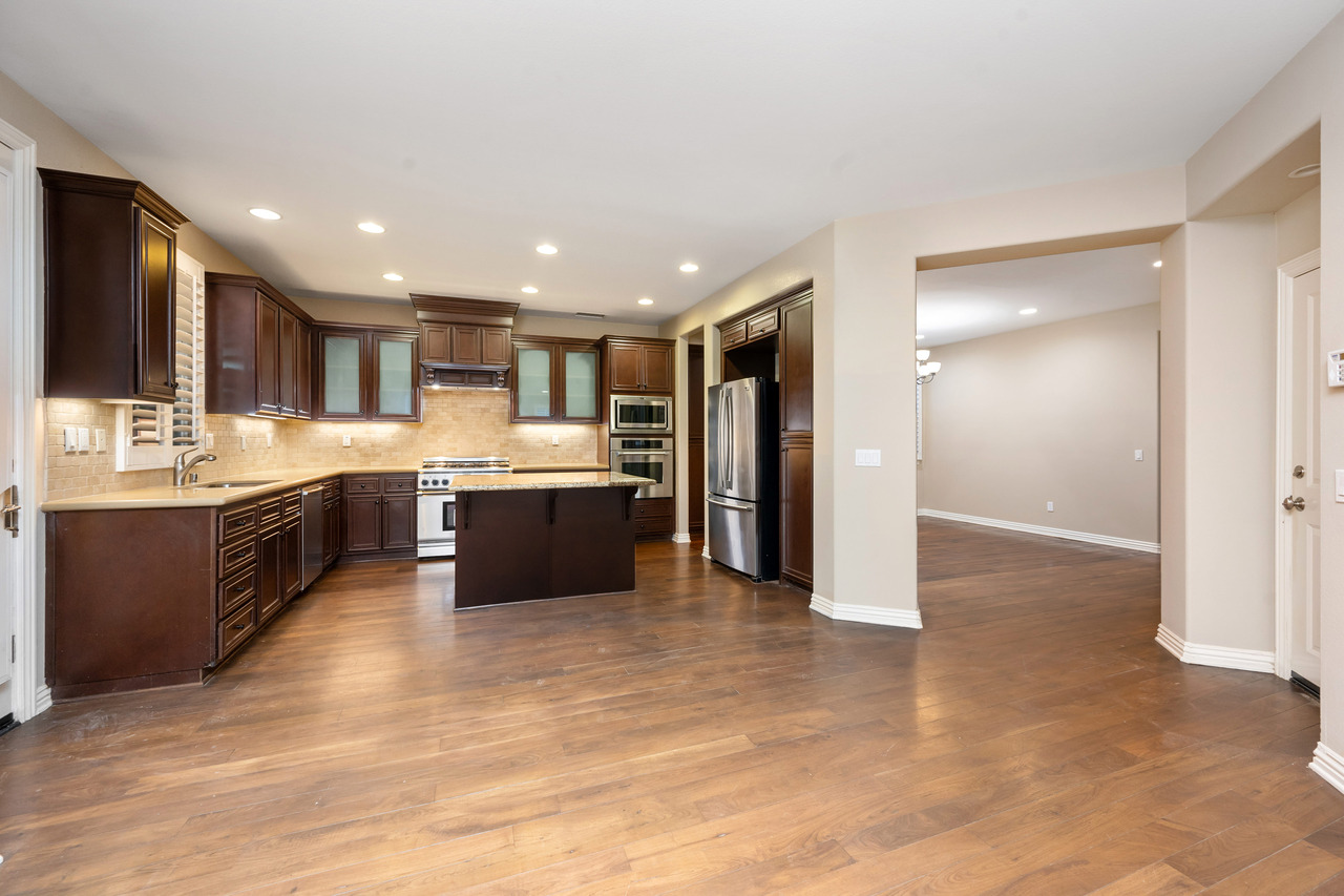 spacious kitchen with hardwood floors and brown ca