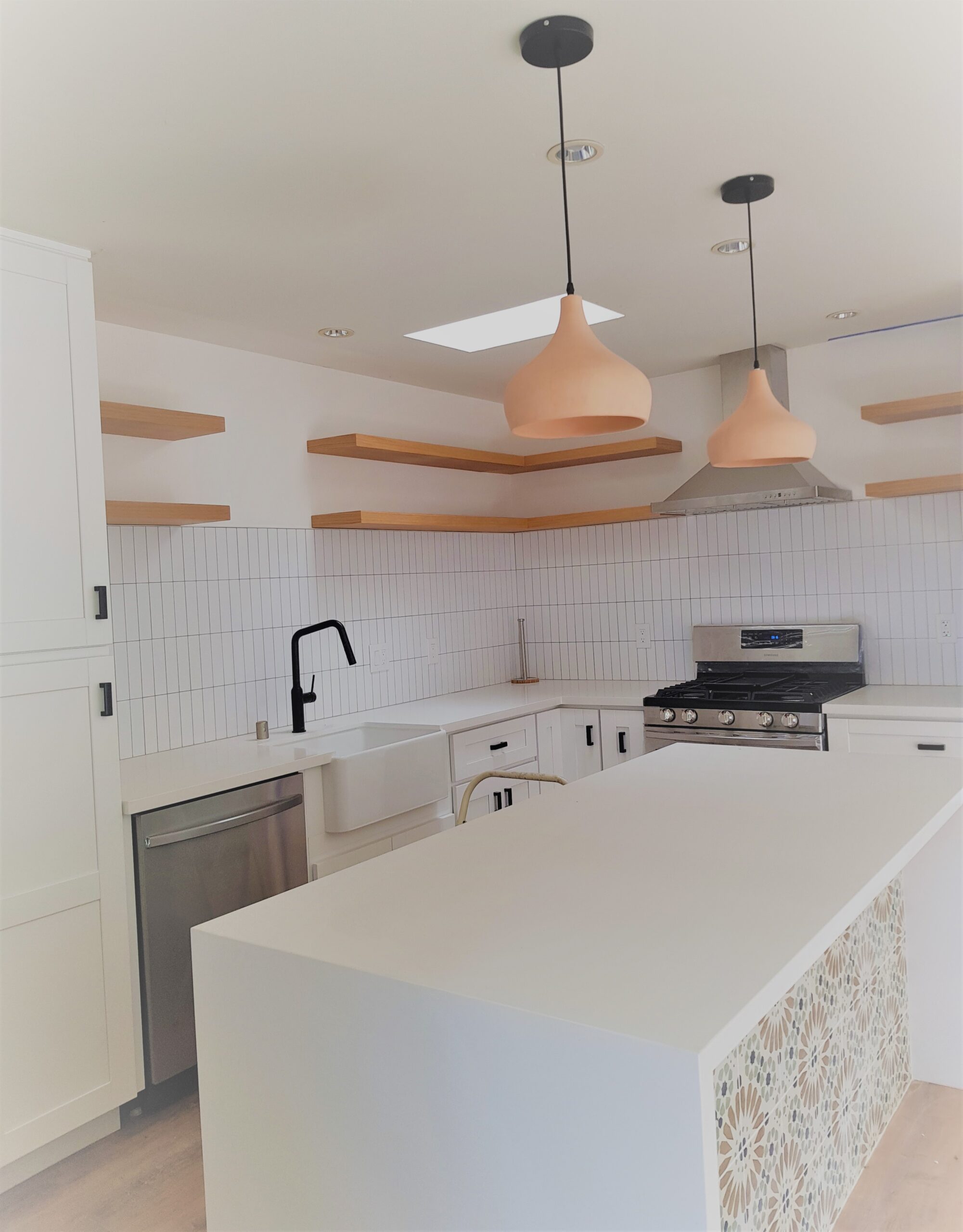 Beach house kitchen design-build Encinitas San Diego — restrained, well-edited open-plan kitchen with single primary sink, clean counters, and disciplined fixture specification