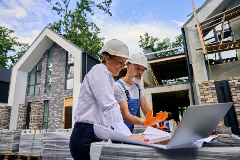 General contractors discussing construction plans at a residential building site