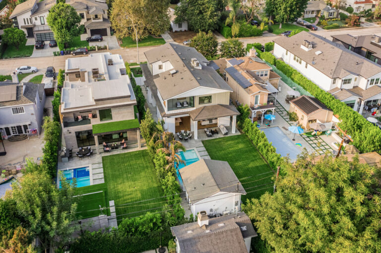 Aerial view of a modern home with a backyard pool and lawn