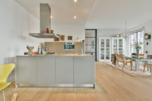 Modern kitchen with a central island, freestanding hood, and dining area in an open-plan layout