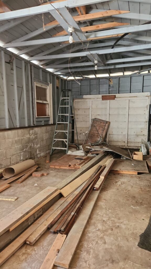 Old garage interior with exposed wood framing before ADU conversion in San Diego