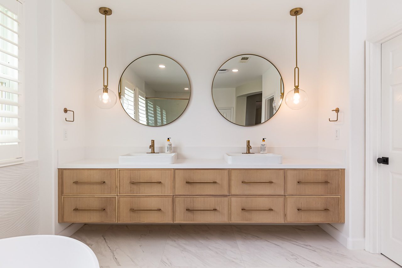 White oak floating vanity with circular mirrors