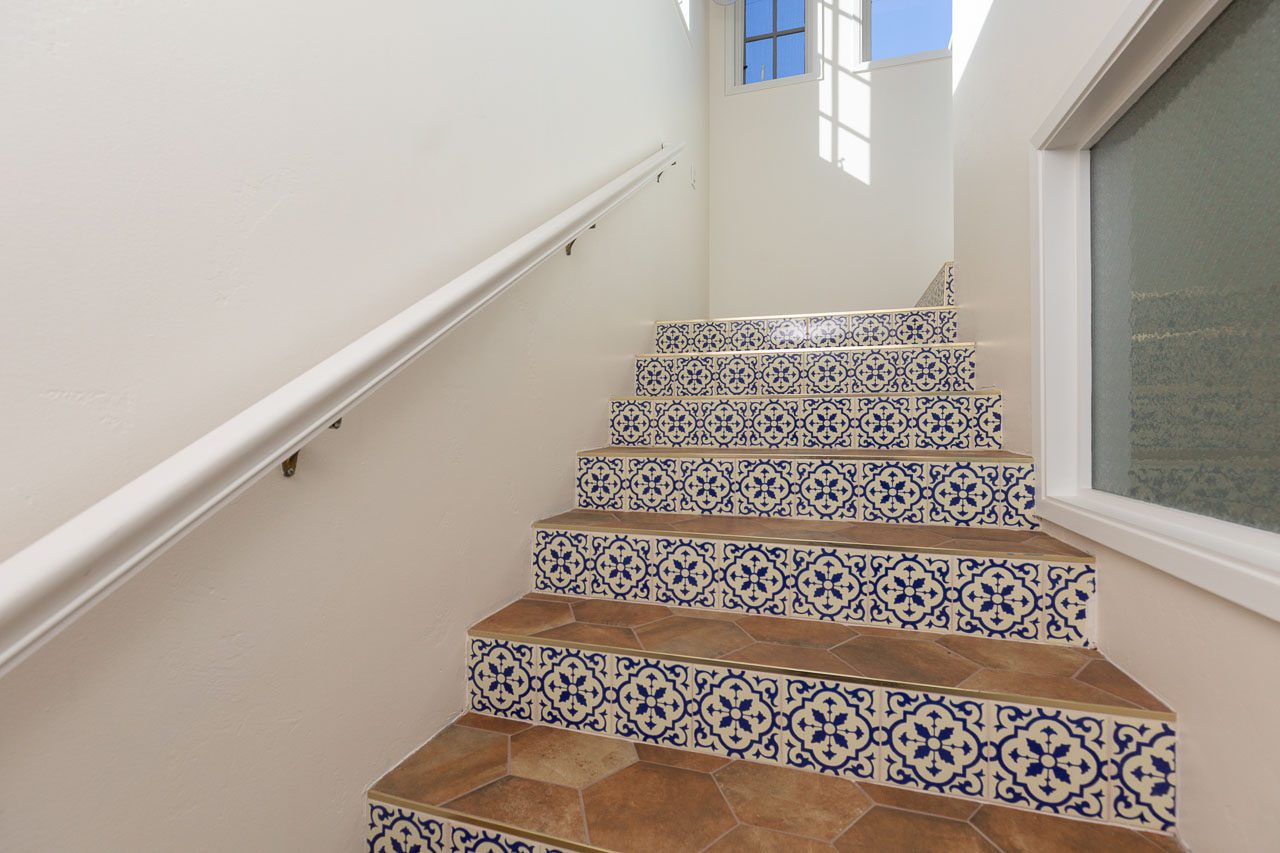 Custom Spanish Revival staircase — terracotta hexagon treads with hand-painted cobalt blue Talavera tile risers, Mission Hills San Diego historic home renovation