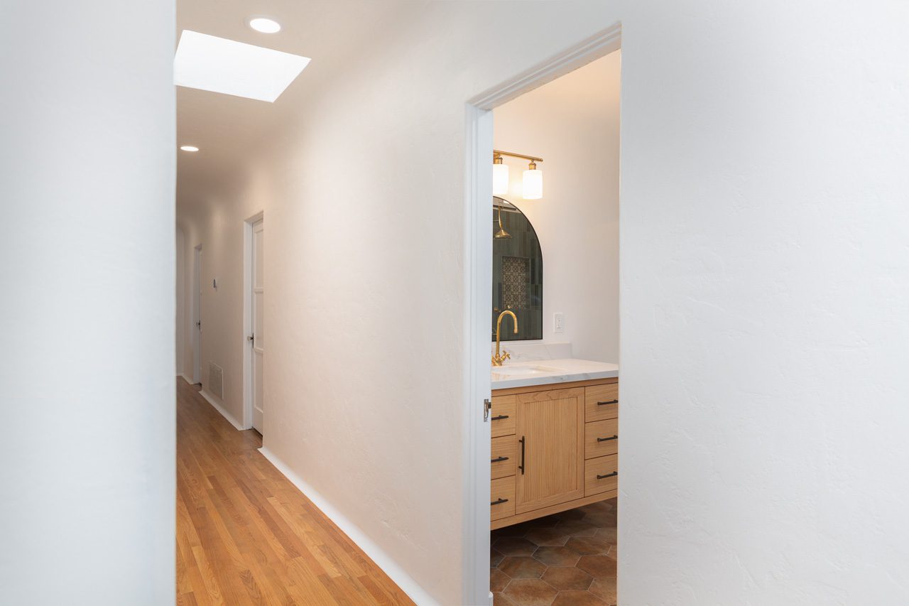 New hardwood flooring and hallway view into Zellige tile bathroom — Spanish Colonial Eclectic whole home renovation Mission Hills San Diego 92103
