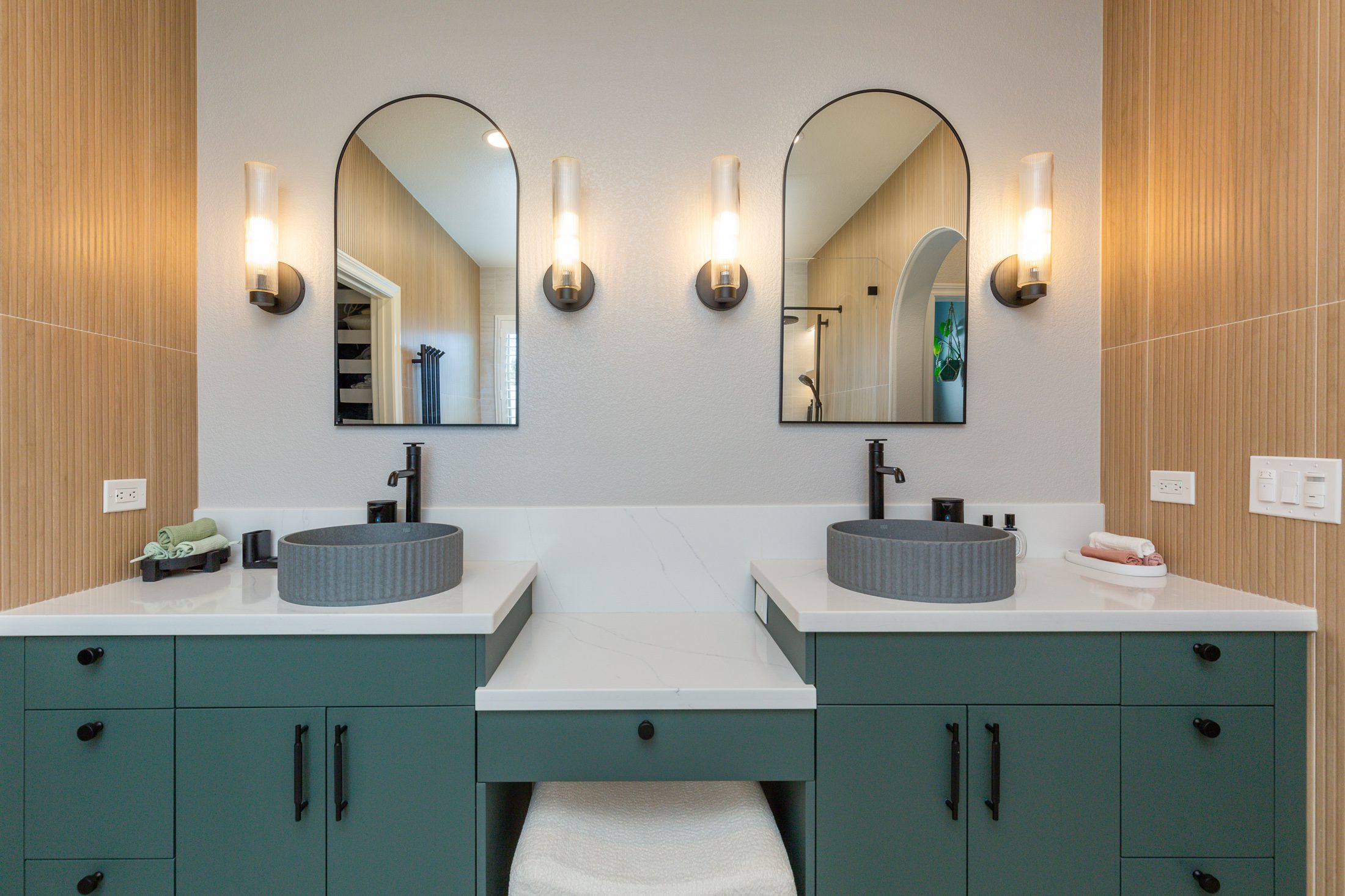 Master bathroom remodel Carmel Valley San Diego 92130 — custom forest green double vanity, paired vessel sinks, matte black fixtures, arch mirrors