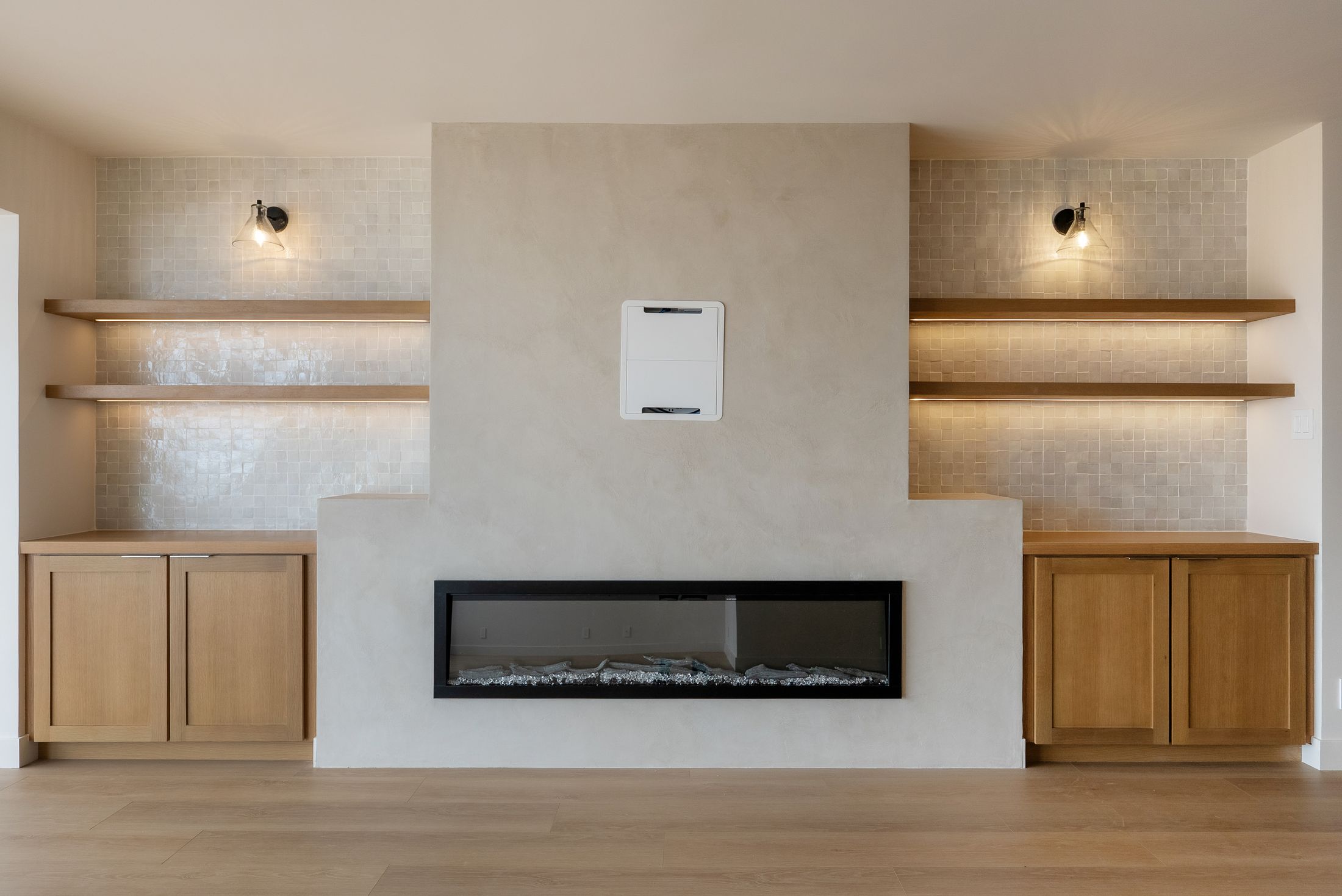 Linear electric fireplace in a plaster surround with zellige niches and white oak cabinets, La Jolla 92037
