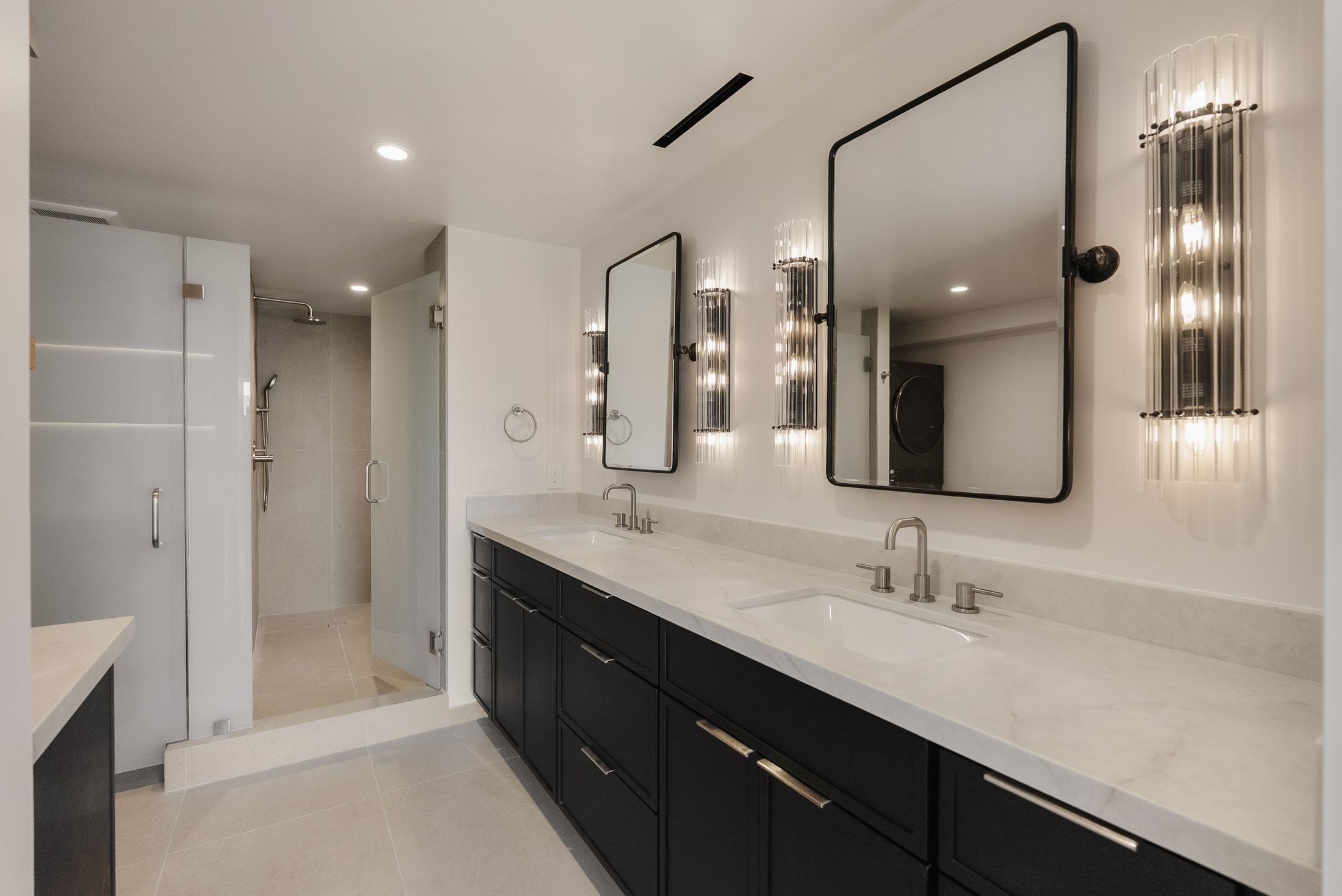 Primary bathroom in La Jolla with matte black double vanity, quartz top, pivot mirrors and walk-in shower